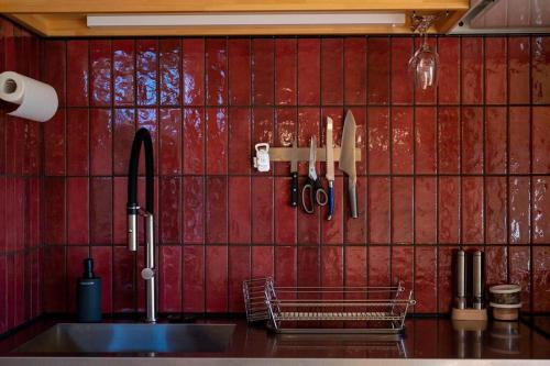 a kitchen with a sink and a red tiled wall at Captain's House, explore the crustal movement every thousand years in Kuroshima