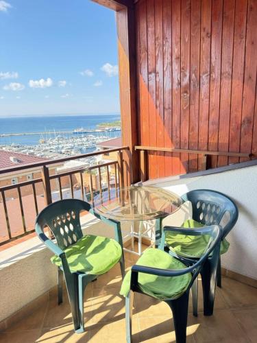 a balcony with two chairs and a glass table at Guest Apartment The Fabulous Sunset -Sozopol in Sozopol