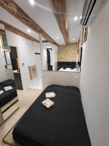 - une chambre avec un lit noir et des serviettes dans l'établissement Jacuzzi, plage, vieux port, à Marseille