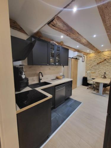 - une cuisine avec des armoires noires et une table dans une pièce dans l'établissement Jacuzzi, plage, vieux port, à Marseille