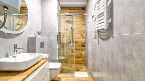 a bathroom with a toilet and a sink and a shower at STEGNA PARK C Apartamenty Piamola WiFi in Stegna