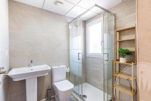 a bathroom with a toilet and a sink and a shower at La Manga Club Las Mimosas Villa 608 in Atamaría