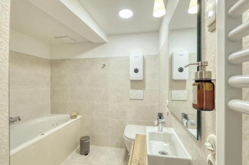 a bathroom with a tub and a toilet and a sink at Ferienwohnungen Steinweg 61 in Quedlinburg