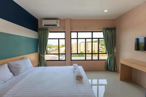 a bedroom with a bed and a large window at JJ Residence Phuket Town in Phuket Town