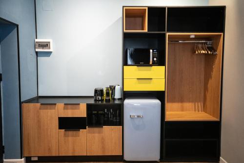 a small kitchen with a refrigerator and a microwave at Emil Balaban Luxury Apart-Hotel in Bucharest