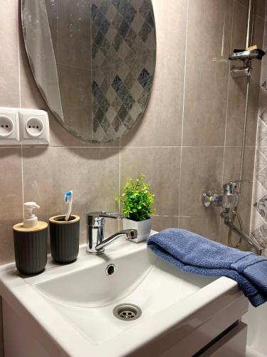 a bathroom sink with two toothbrushes and a mirror at Квартира-студия в центре города in Balqash