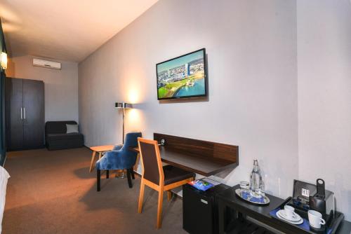 a hotel room with a desk and a table with a piano at BOUTIQUE HOTEL11 with rooftop SPA in Nitra