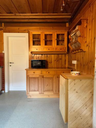 a kitchen with wooden cabinets and a counter with a microwave at Ferienhaus - Senn-Inn im Zentrum von Schladming in Schladming