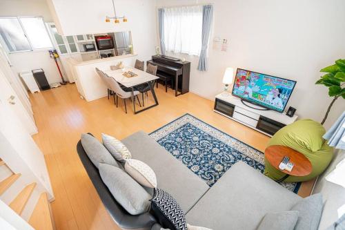 a living room with a couch and a table and a television at new open 貸切一軒家 新大久保駅徒歩13分 大久保駅徒歩7分 西新宿駅徒歩9分 in Tokyo