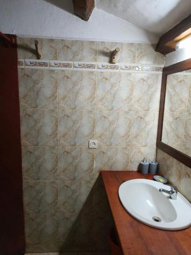a bathroom with a sink and a marble wall at Suarez Hotel in Diego Suarez