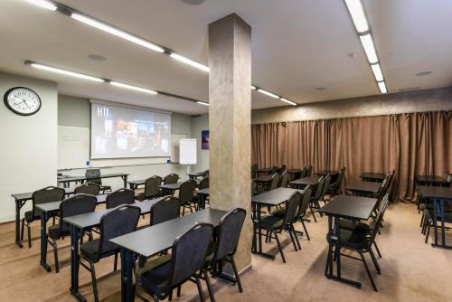 a classroom with tables and chairs and a projection screen at BOUTIQUE HOTEL11 with rooftop SPA in Nitra