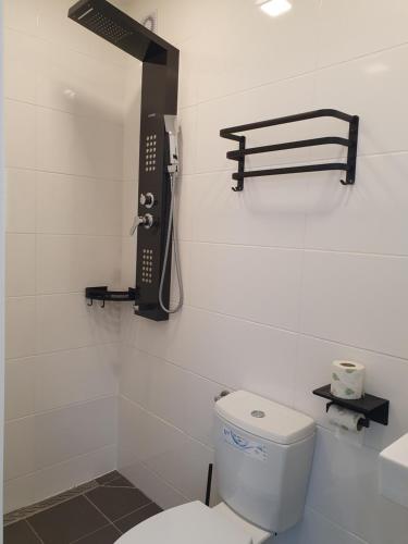 a bathroom with a toilet and a phone on the wall at Pension Valentina in Mühlau