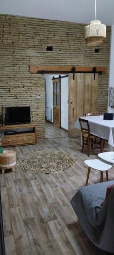 a living room with a table and a brick wall at L'Oustal in Montech