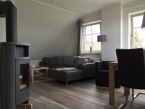 a living room with a couch and a fireplace at FeWo Lindenhof in Alt Reddevitz