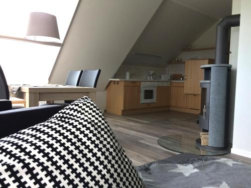 a living room with a couch and a kitchen at FeWo Lindenhof in Alt Reddevitz
