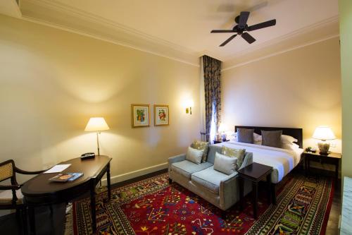 a hotel room with a bed and a couch at Galle Face Hotel in Colombo