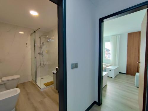 a bathroom with a shower and a toilet and a glass door at Apartamento SEREN AGUA in Moledo