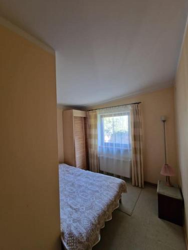 a bedroom with a bed and a window at Ezermalas in Carnikava