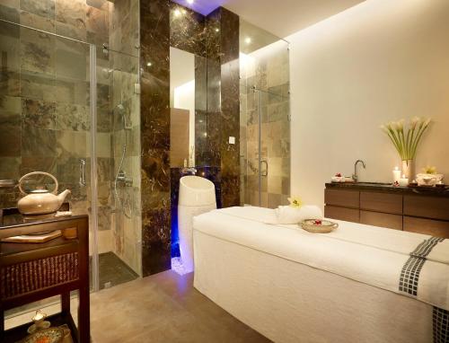 a bathroom with a shower and a bed in a room at Vivanta Pune, Hinjawadi in Pune