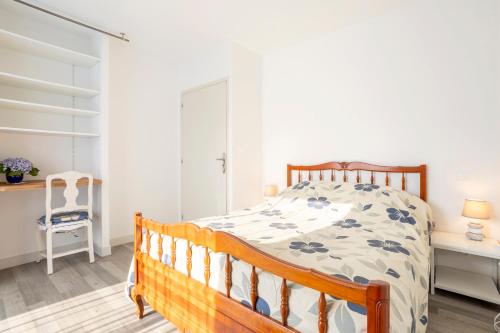 - une chambre avec un lit en bois et un bureau dans l'établissement Maison avec terrasse et jardin, à Saint-Yvy