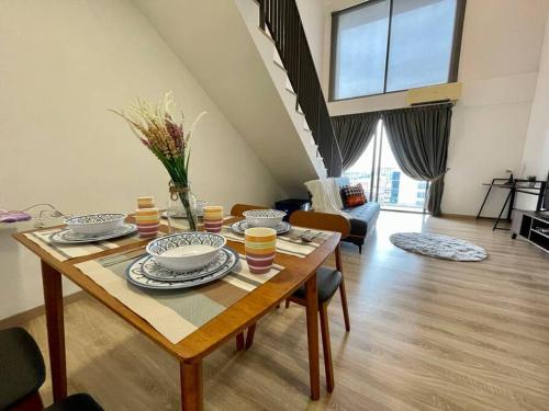 a living room with a wooden table with dishes on it at Emporis8 Netflix at SEGI Emhub Kota Damansara IKEA in Petaling Jaya