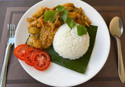 a plate of food with rice and tomatoes on a table at Konglor Cave Resort-Riverside Restaurant in Ban O