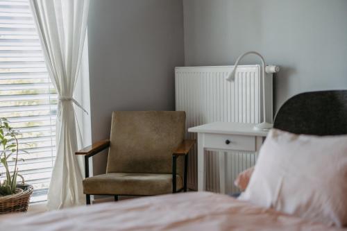a bedroom with a chair and a bed at Cozy Place in Müllendorf