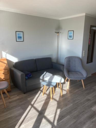 a living room with a couch and a table and chairs at FeWo Lindenhof in Alt Reddevitz