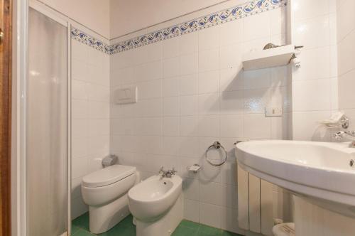 a white bathroom with a toilet and a sink at Sant'Antonio in Volterra