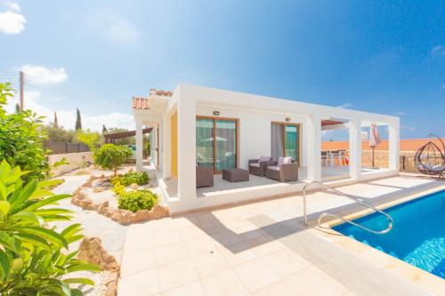 a villa with a swimming pool next to a house at Villa Helena in Peyia