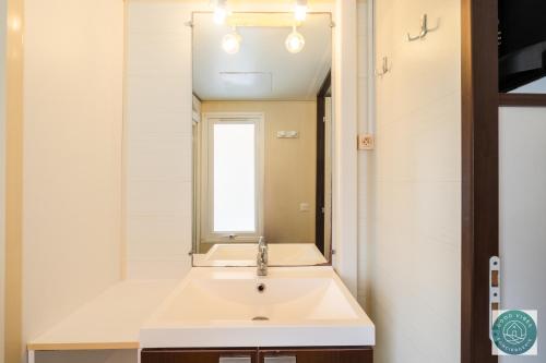 une salle de bain avec un lavabo et un miroir dans l'établissement Mobilhome au rythme des Îles Sérénité & Nature, à Bias