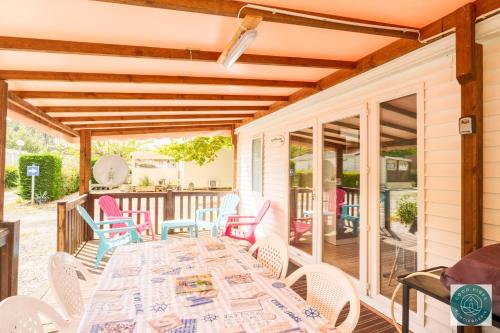 un patio avec une table et des chaises sur une terrasse dans l'établissement Mobilhome au rythme des Îles Sérénité & Nature, à Bias