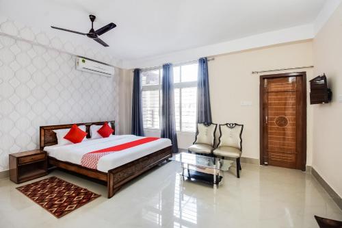 a bedroom with a bed and a chair in it at Super Hotel O Royal Pearl Inn in Guwahati