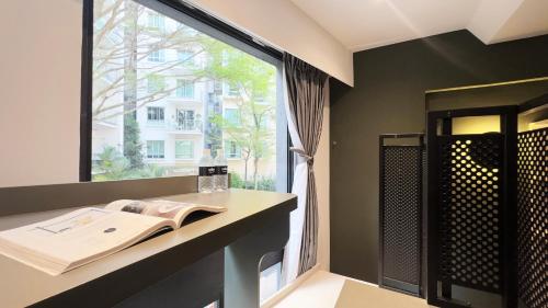 Un baño con lavabo y una gran ventana. en Coliwoo 268 River Valley - CoLiving, en Singapur