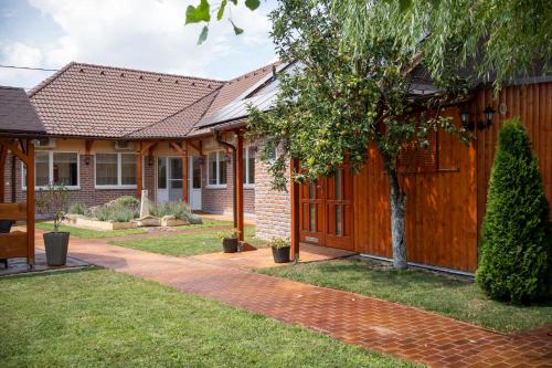 a house with a wooden fence in a yard at Holiday Apartmanház Gyula in Gyula
