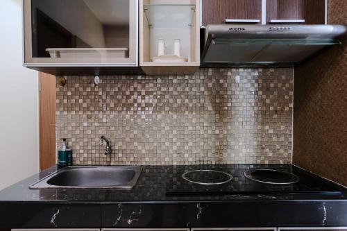 a kitchen with a sink and a stove at Spacious 3BR Combined Unit at Pinewood Apartment By Travelio in Sumedang