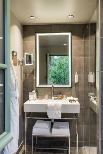 a bathroom with a sink and a mirror at Dolce by Wyndham Versailles - Domaine du Montcel in Jouy-en-Josas