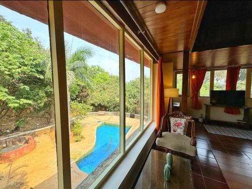 a room with a view of a pool through a window at Captans Stay in Lonavala