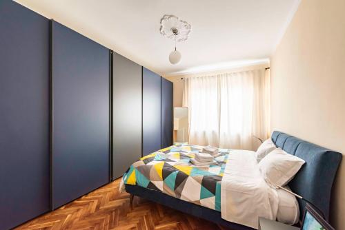 a bedroom with a bed and a blue wall at Happy Venaria by Rentbeat in Venaria Reale
