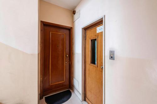 a hallway with a wooden door and a window at Happy Venaria by Rentbeat in Venaria Reale
