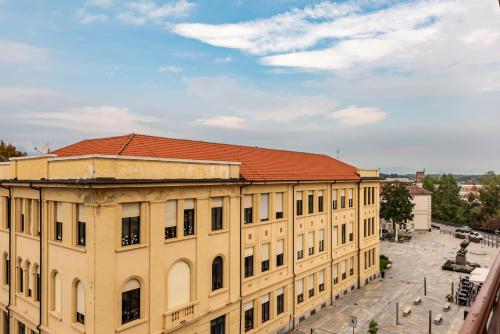 an old yellow building with a red roof at Happy Venaria by Rentbeat in Venaria Reale