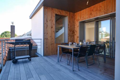 un patio avec une table et des chaises sur une terrasse dans l'établissement Jolie maison de ville rénovée avec goût proche toutes commodités quartier Arago Les Sables - 13 personnes, à Les Sables-dʼOlonne