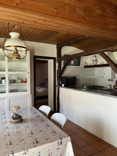 une cuisine avec une table et des chaises dans une pièce dans l'établissement Charmante maison de vacances, à Saint-Jean-de-Monts