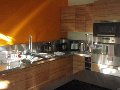 une cuisine avec un évier et une cuisinière four supérieur dans l'établissement Loft New Yorkais in Paris Bercy, à Vitry-sur-Seine