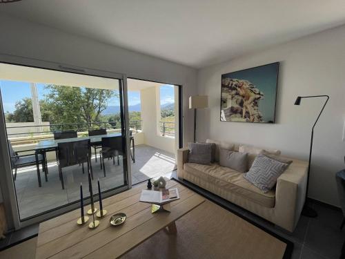 un salon avec un canapé et une table dans l'établissement Charmant T3 dans une résidence neuve avec piscine, à Calvi