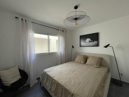 une chambre avec un lit et une fenêtre dans l'établissement Charmant T3 dans une résidence neuve avec piscine, à Calvi