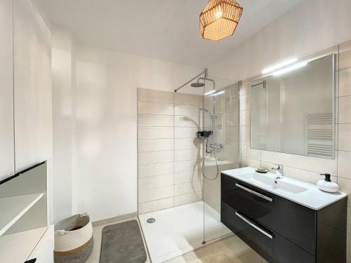 une salle de bain blanche avec un lavabo et une douche dans l'établissement Grand T3 vue sur la baie de Calvi, à Calvi