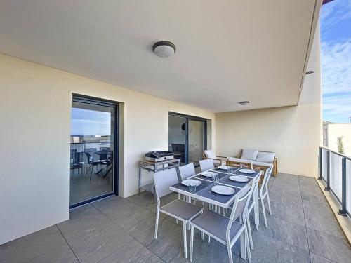 une salle à manger avec une table et des chaises sur un balcon dans l'établissement T3 vue sur la baie de Calvi, à Calvi