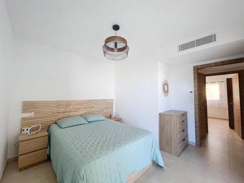 une chambre avec un lit et une tête de lit en bois dans l'établissement T3 vue sur la baie de Calvi, à Calvi