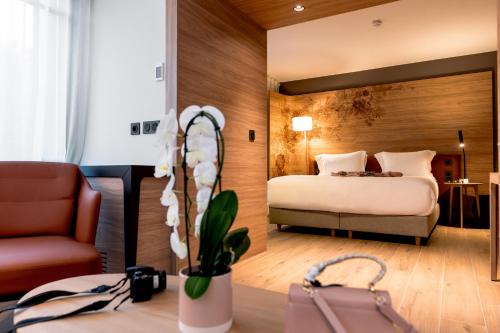 a hotel room with a bed and a chair at Dolce by Wyndham Versailles - Domaine du Montcel in Jouy-en-Josas